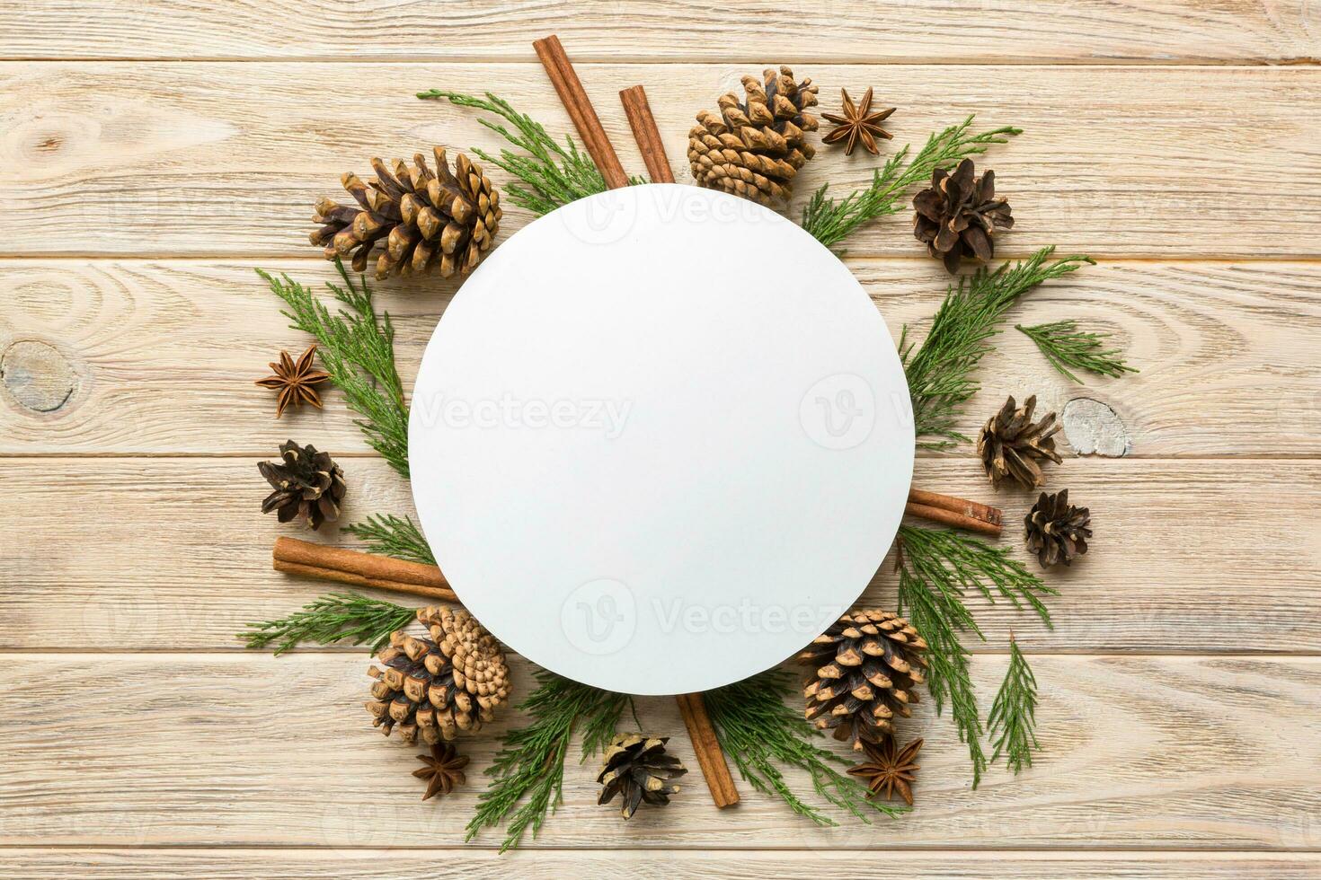 Flat lay Christmas composition. Round Paper blank, pine tree branches, christmas decorations on Colored background. Top view, copy space for text photo