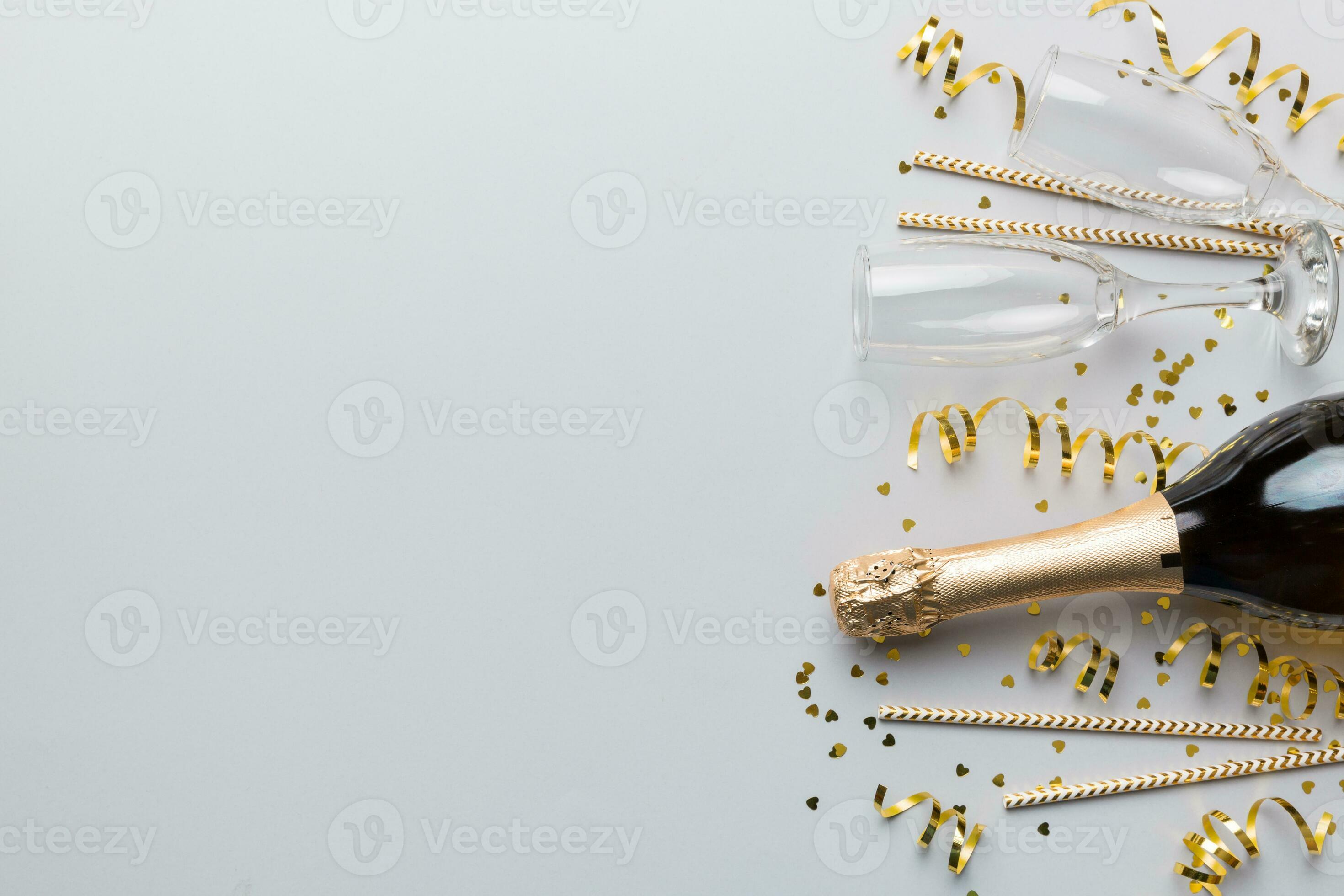 Champagne bottle, glitter and straws on color background. top view