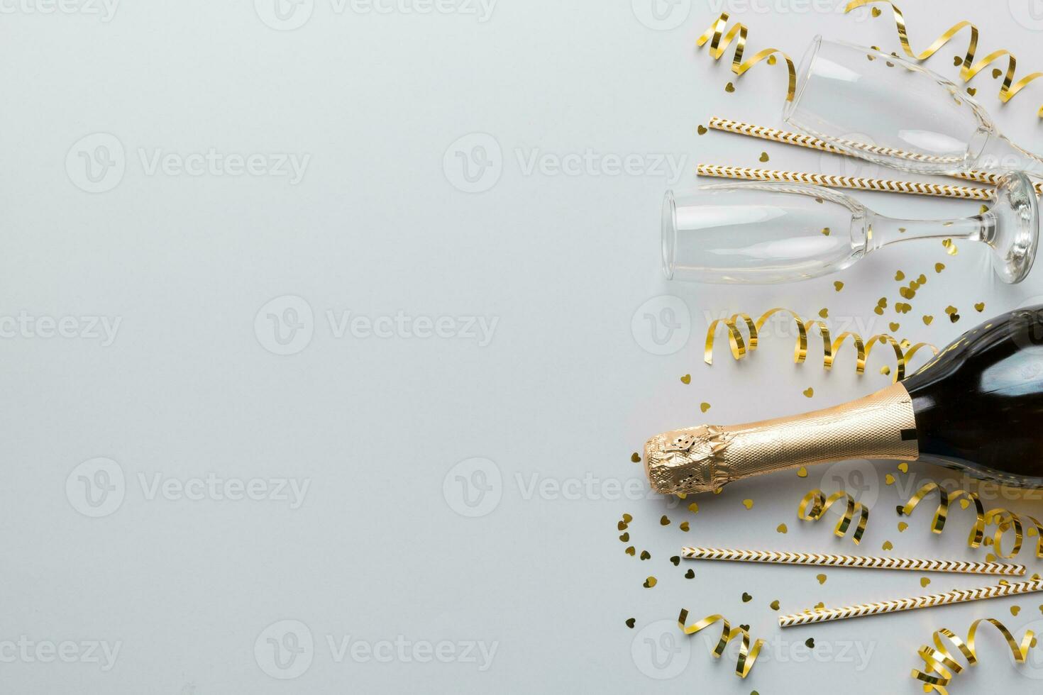 Champagne bottle, glitter and straws on color background. top view. Hilarious, christmas and birthday celebration photo