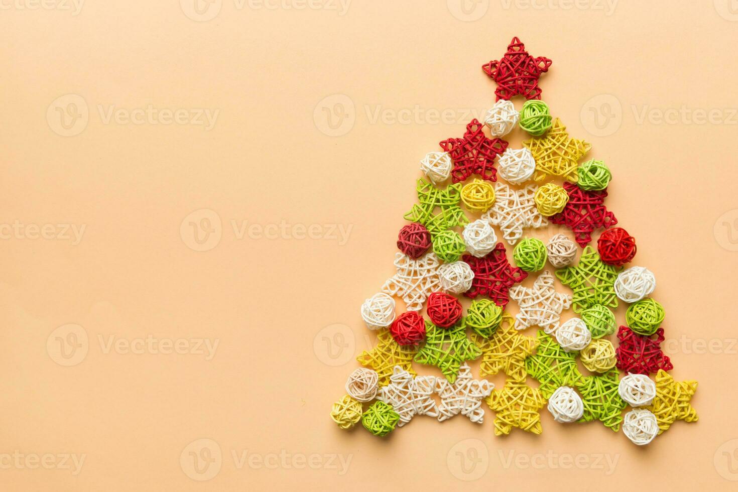 Christmas tree made from colored handmade ball decoration on colored background, view from above. New Year minimal concept with copy space photo