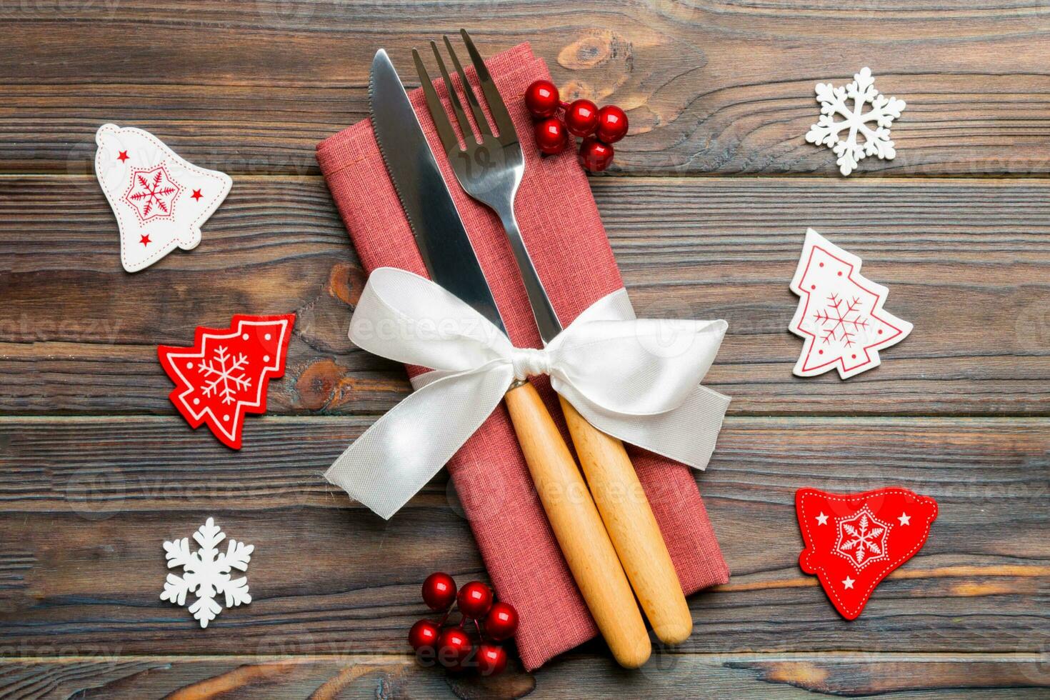 Top view of festive cutlery on new year wooden background. Close up of christmas decorations. Holiday dinner concept photo