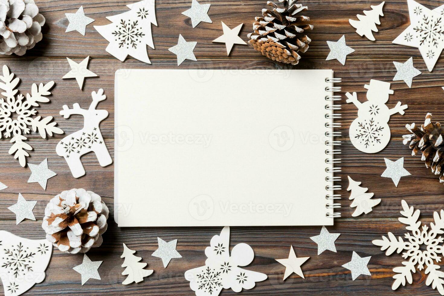 Top view of notebook on wooden background made of Christmas decorations. New Year concept photo