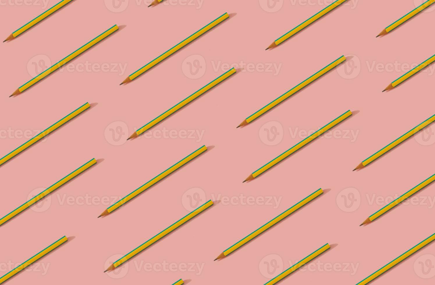 Back to school. Pattern composition of yellow and blue pencils on pastel pink background. Minimalist back to school concept. Trendy pencils pattern background. photo