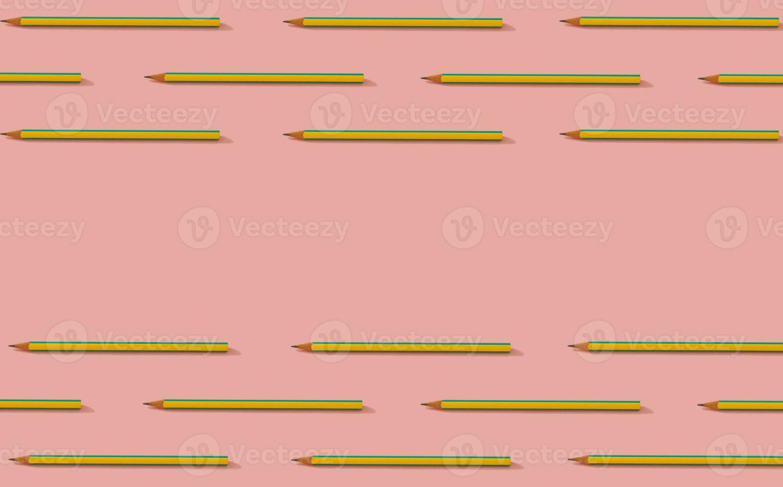 Back to school. Creative pattern composition of yellow and blue pencils on pastel pink background. Minimalist back to school concept. Trendy pencils pattern background. Copy space for text. photo