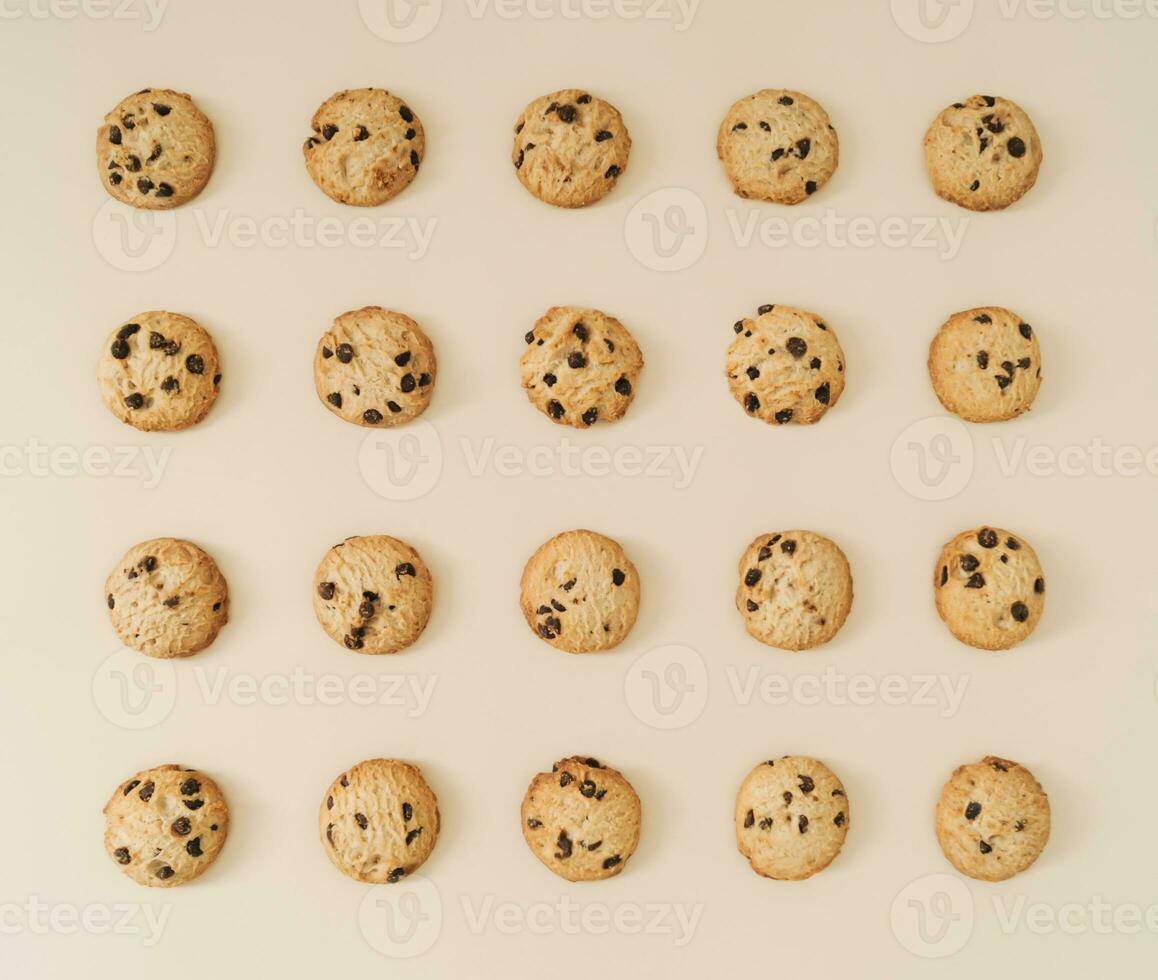 Creative chocolate cookies pattern on pastel cream background. Minimal food concept. Yummy chocolate biscuits idea. Flat lay cookies composition. Top of view. photo