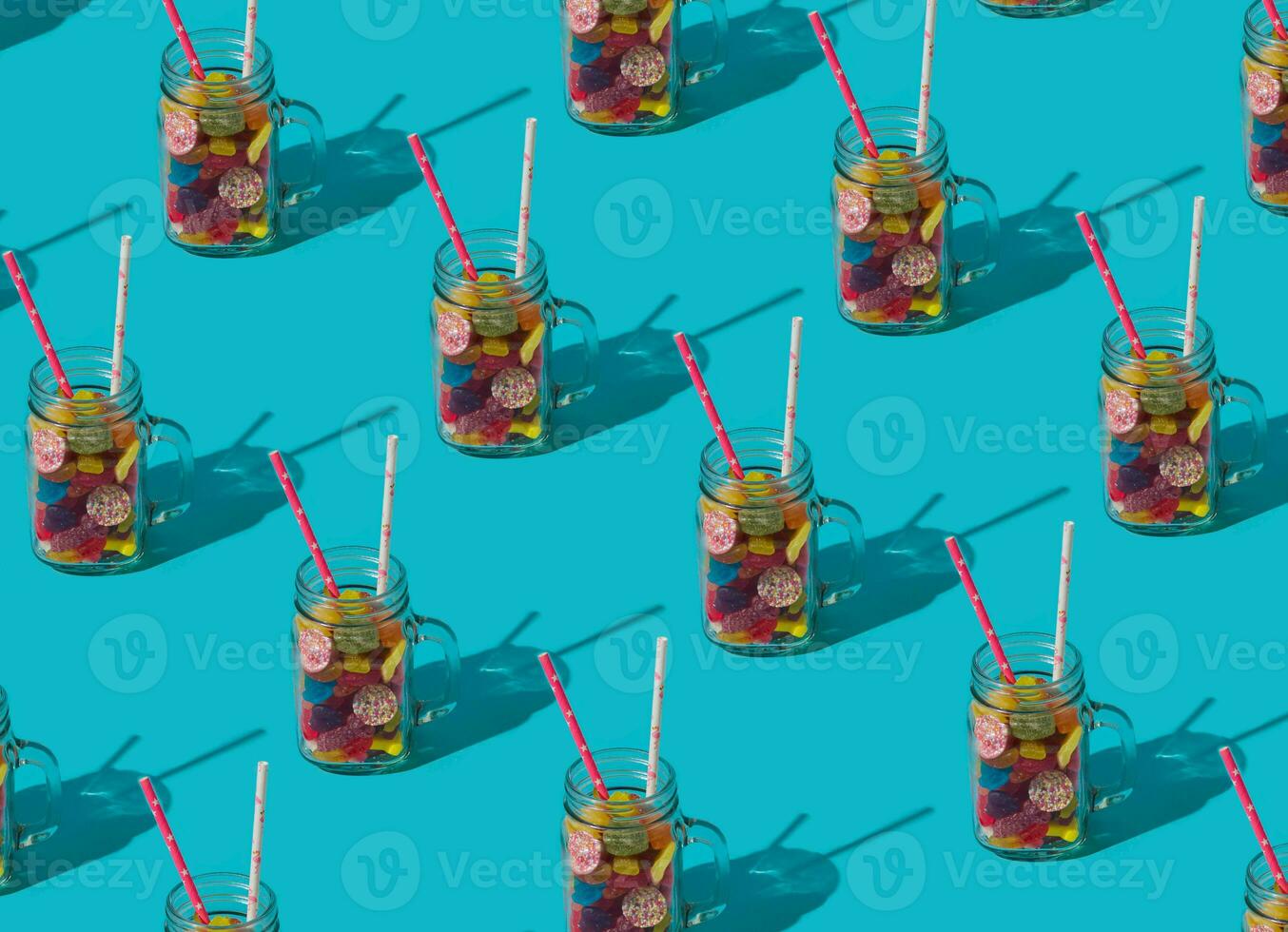 Trendy summer cocktail pattern made of colorful gummy candies on light blue background. Minimal creative idea. Nature beach concept. photo