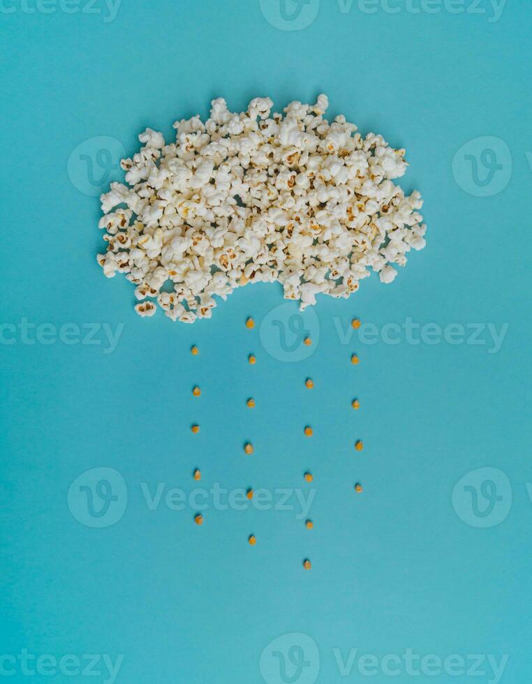 Creative design of cloud made of popcorn on light blue background. Minimal concept. photo