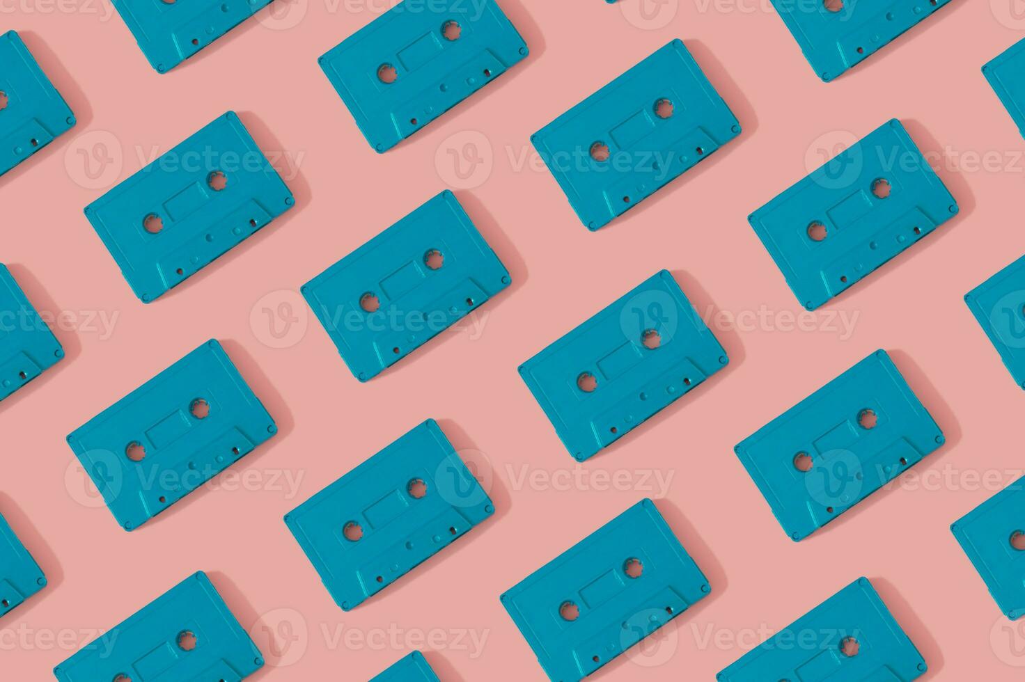 Pattern made with retro blue audio cassette tapes on modern pink background. Creative concept of retro technology. 80's aesthetic. Retro vintage audio cassette tape pattern idea. Flat lay. photo