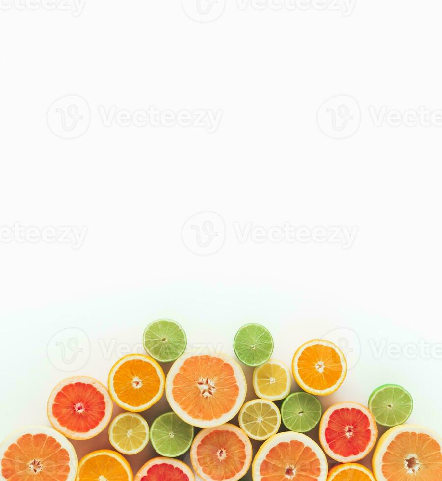 Creative summer concept made of various citrus fruits on white background. Minimal layout. Flat lay, top of view. photo