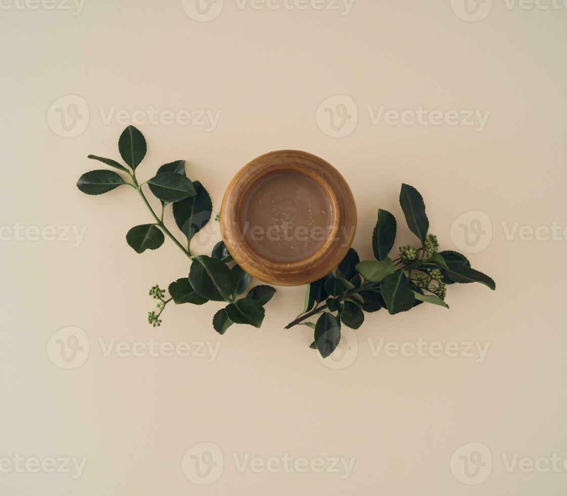 Creative minimal arrangement of green leaves and cup of coffee on pastel background. Nature composition. Coffee flat lay concept. Top of view. photo