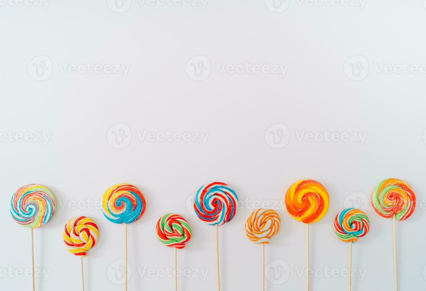 Lollipops with bold colors on white background. Summer concept. Creative candy composition. Minimal sweet idea. Copy space for text. photo