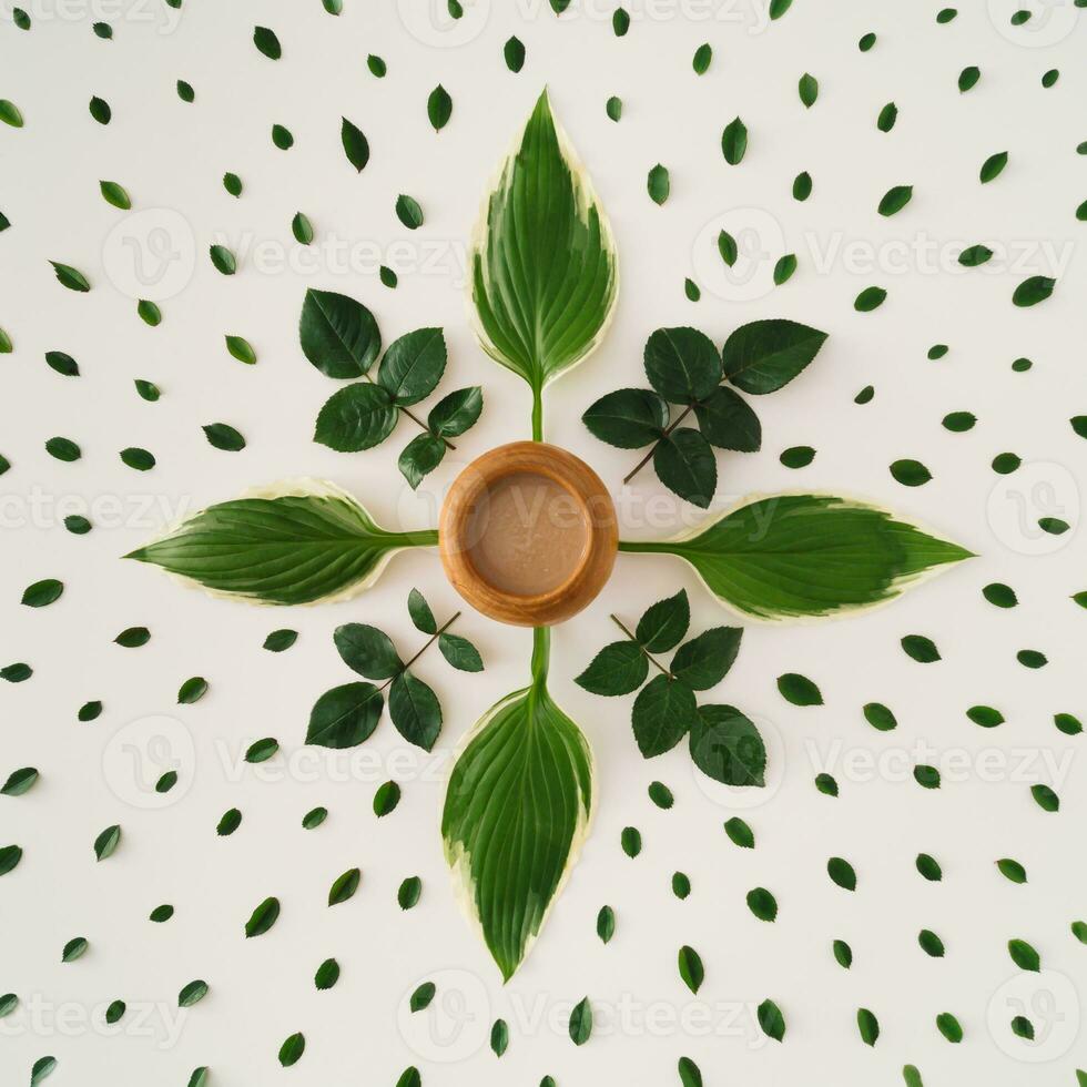 Creative minimal arrangement of green leaves and cup of coffee. Nature composition. Coffee flat lay concept. photo