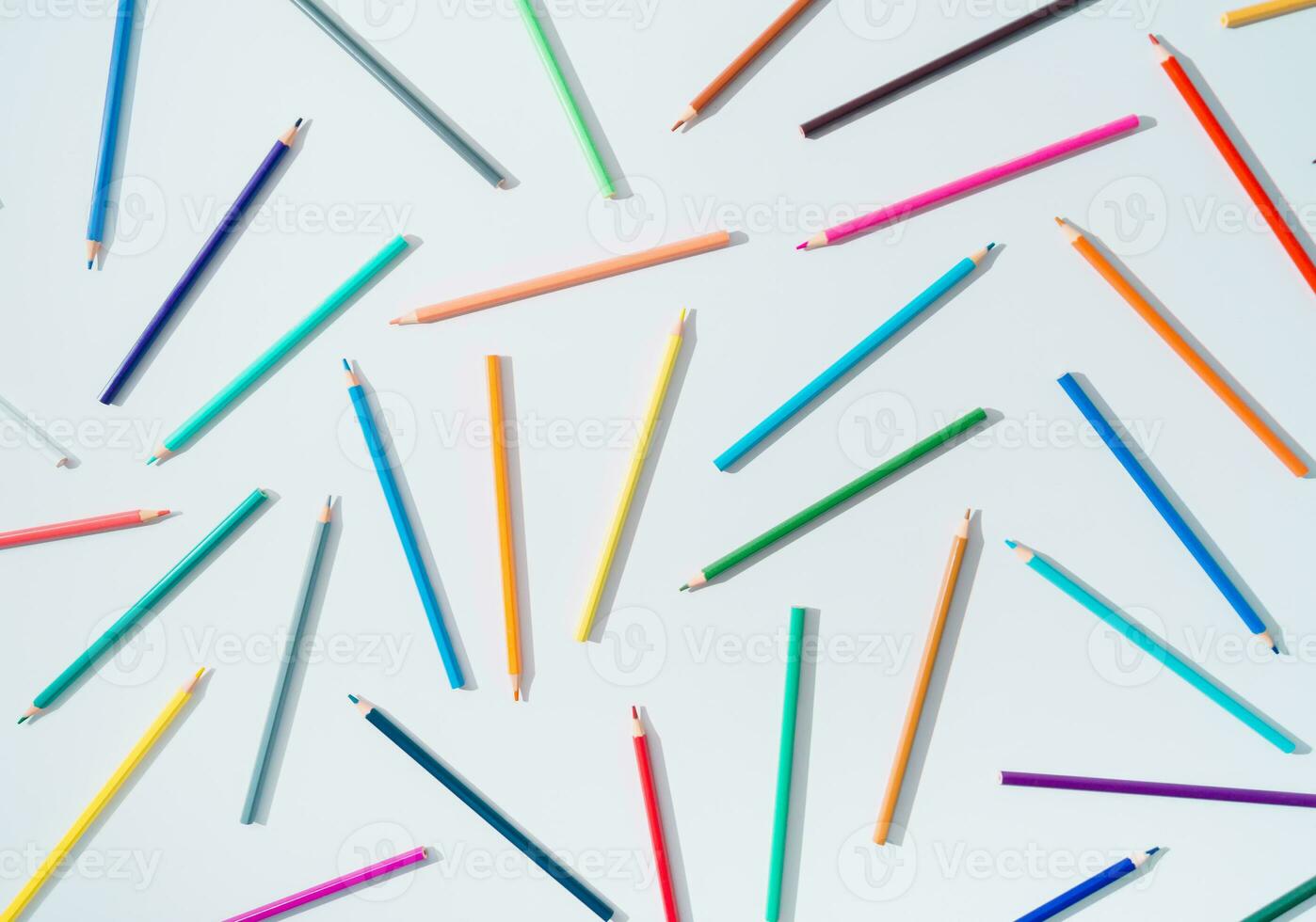 Creative colorful pattern made of colored pencils on white background. Minimal back to school concept. Trendy colored pencils pattern idea. Flat lay background. photo