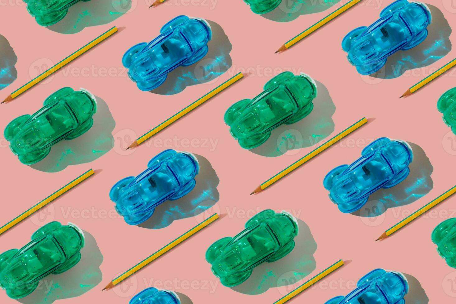 Trendy racing cars pattern made of pencils and pencil sharpeners on pastel pink background. Minimal school concept. Creative school objects pattern. Colorful background idea. photo