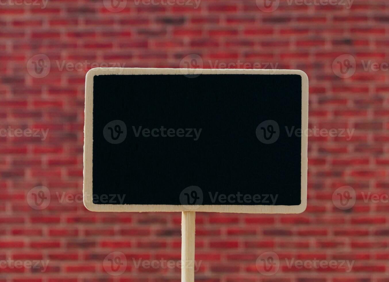 Creative layout made of black writing board against red brick wall background.  Minimal black writing board concept. Trendy background with copy space idea. photo