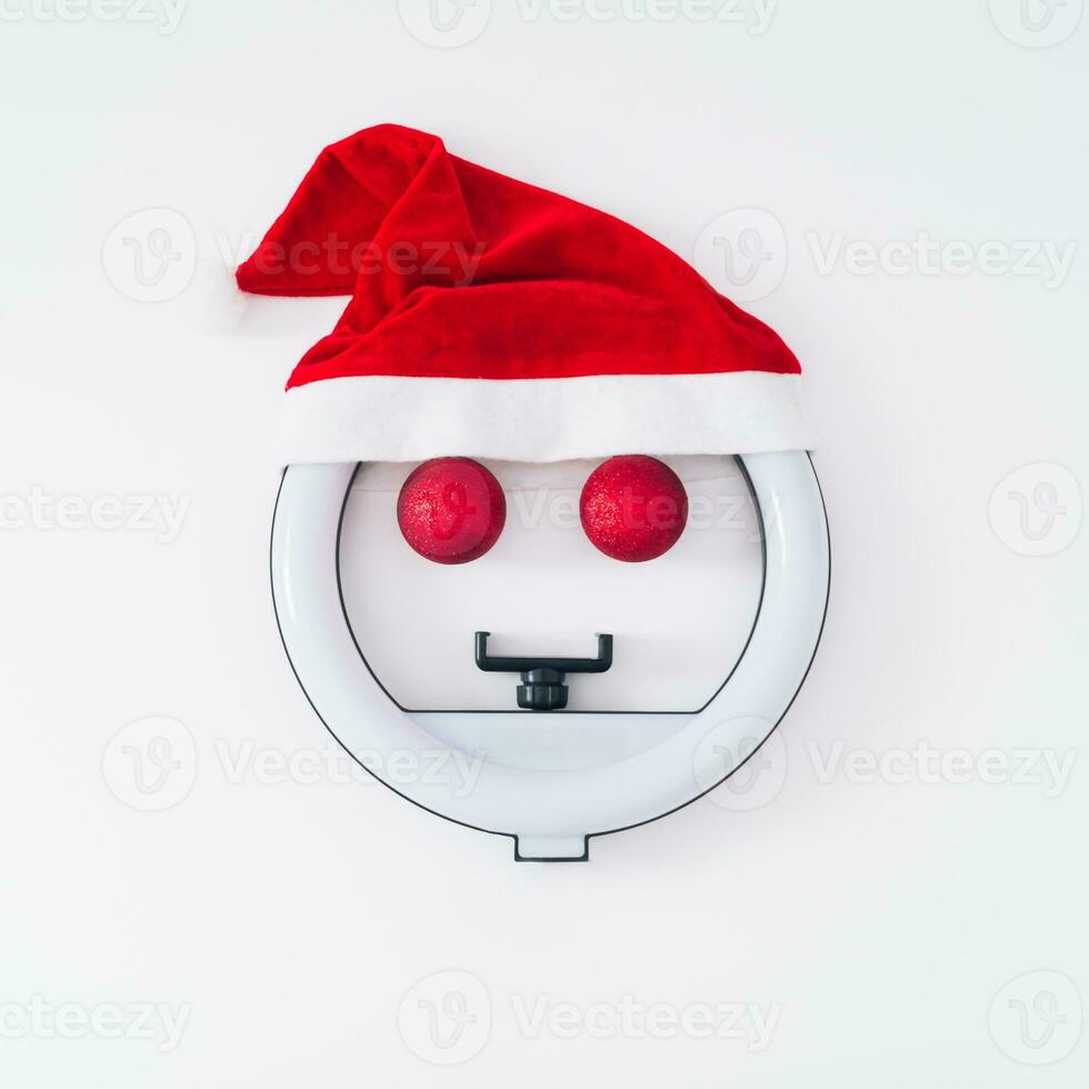 Creative Christmas layout made of TikTok ring light, Christmas baubles and Santa Claus hat on white background.  Minimal TikTok and social media Christmas or New Year concept. Flat lay. photo