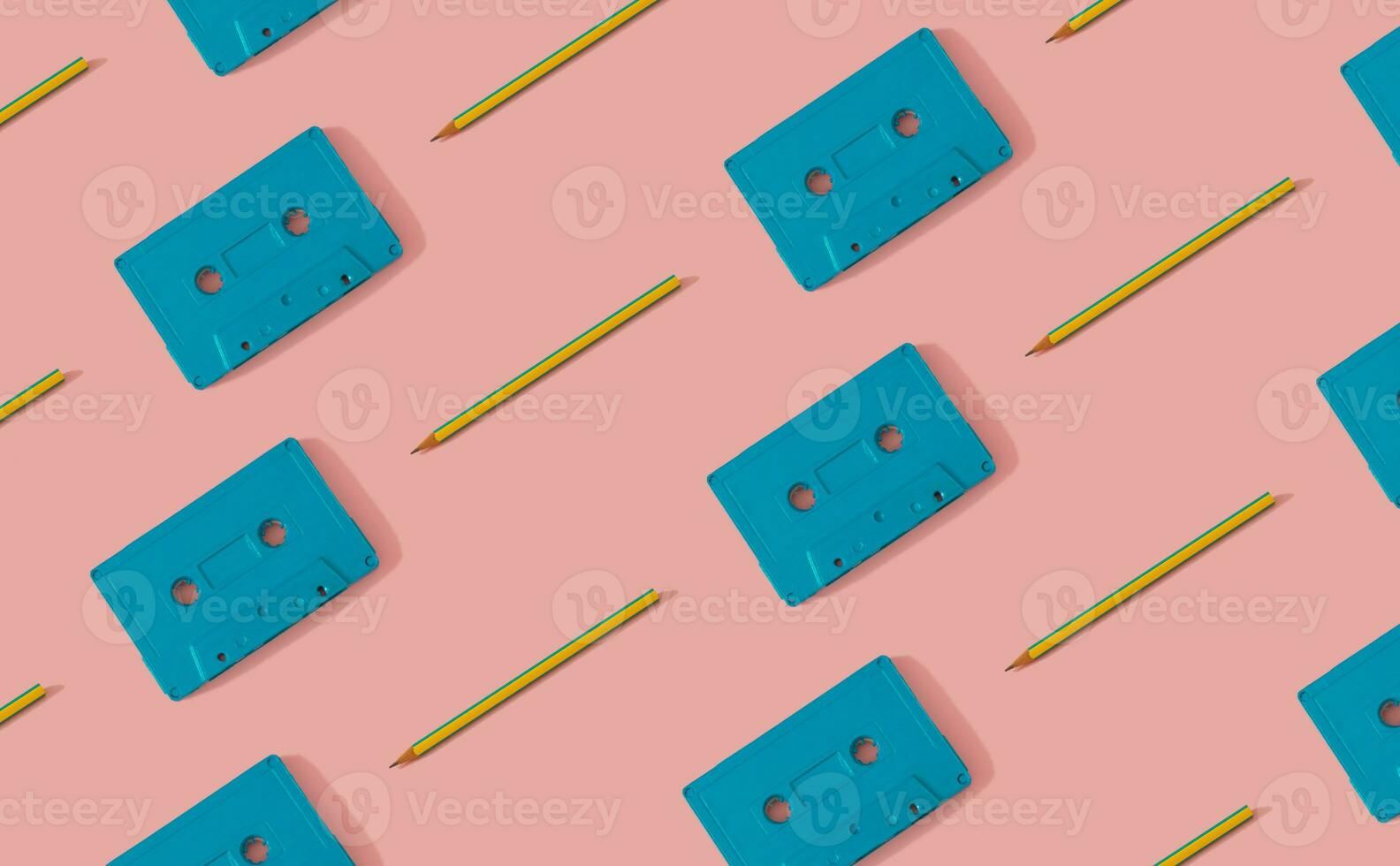 You're the pencil to my cassette tape. Retro cassette tapes and pencils pattern on light pastel pink background. Creative music old cassettes pattern. Retro fashion aesthetic background. photo
