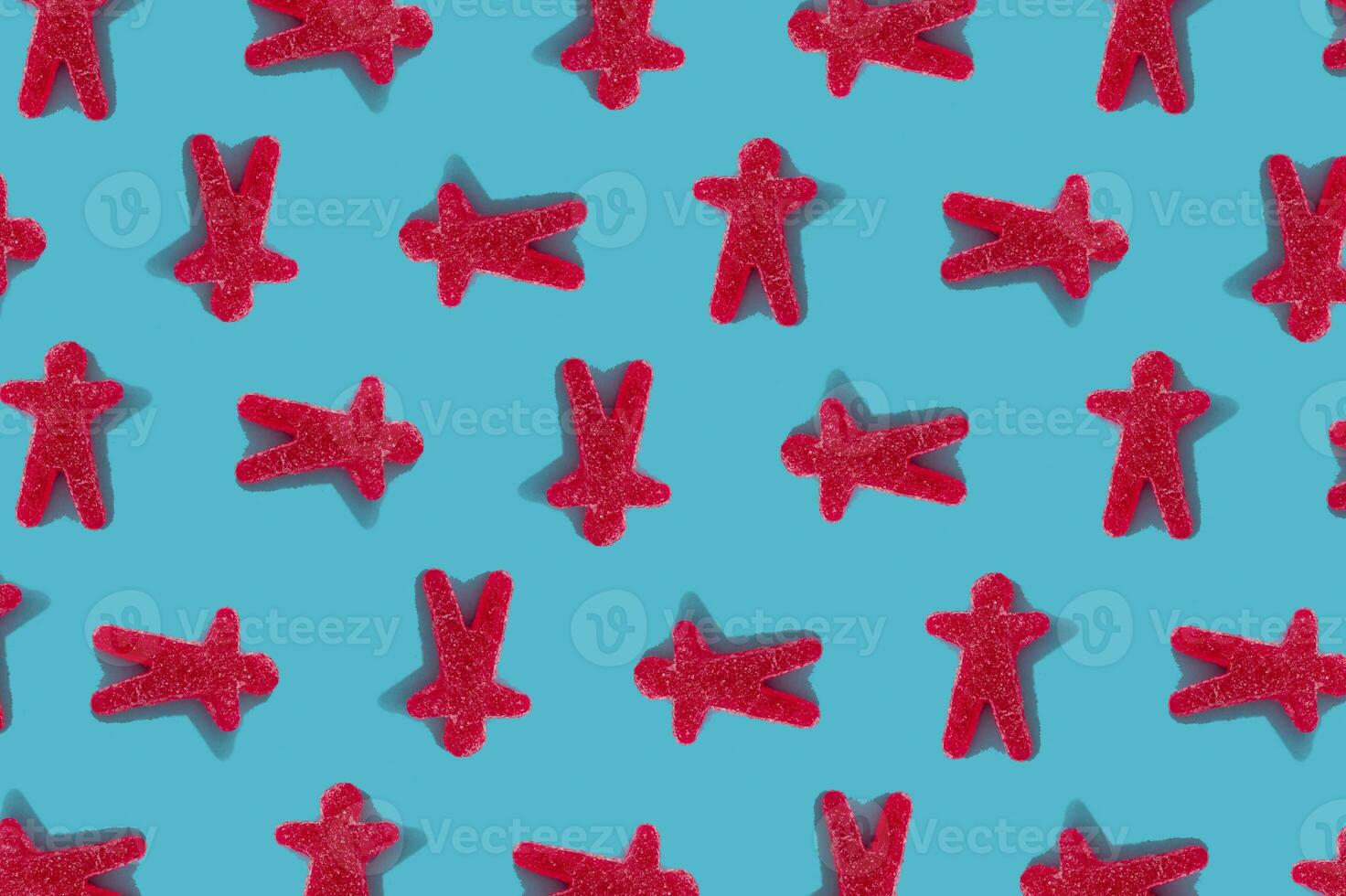 Creative pattern of humans made of gummy candies on bright blue background. Minimal concept idea. Flat lay. photo