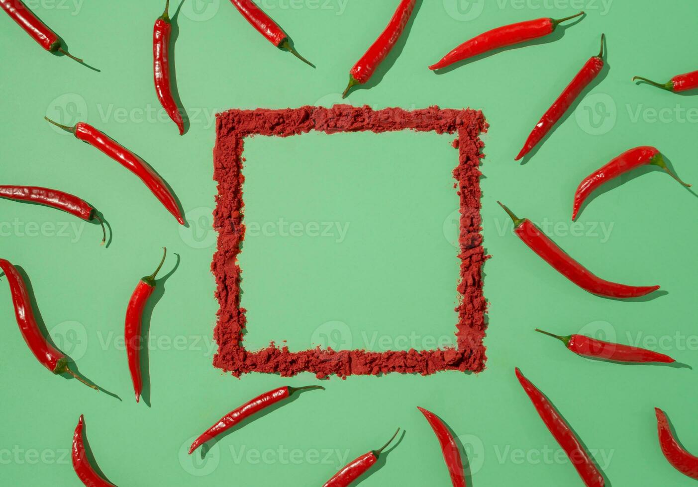 Creative pattern made of red hot chili peppers on pastel green background with natural frame.  Minimal flat lay. photo