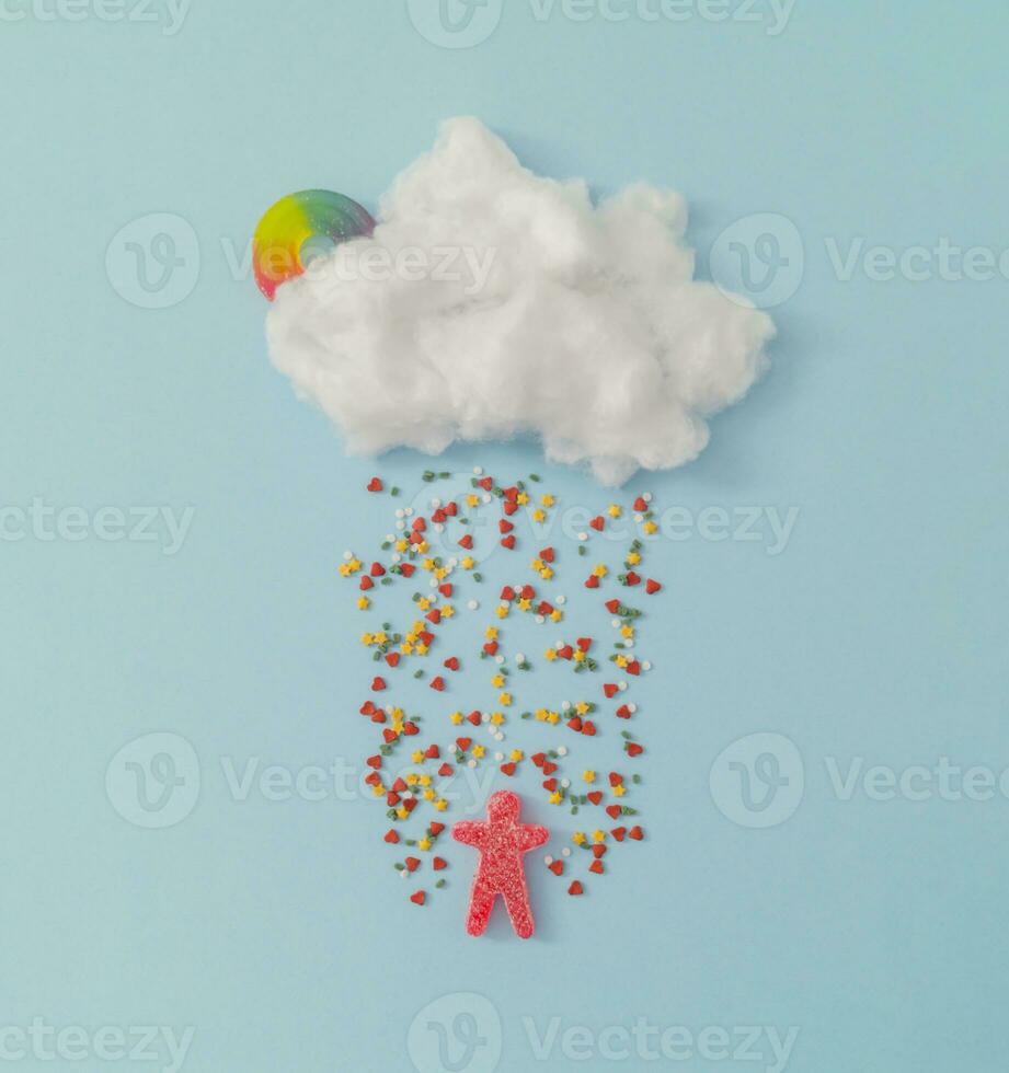 Creative cloud with colorful sprinkles and gummy candy. Minimal concept background. photo