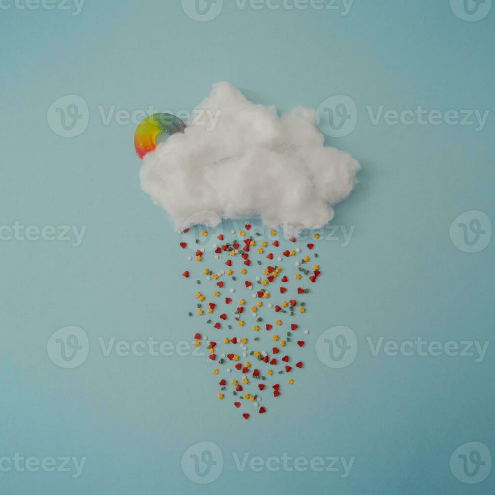 Creative cloud with colorful sprinkles and gummy candy. Minimal concept background. photo