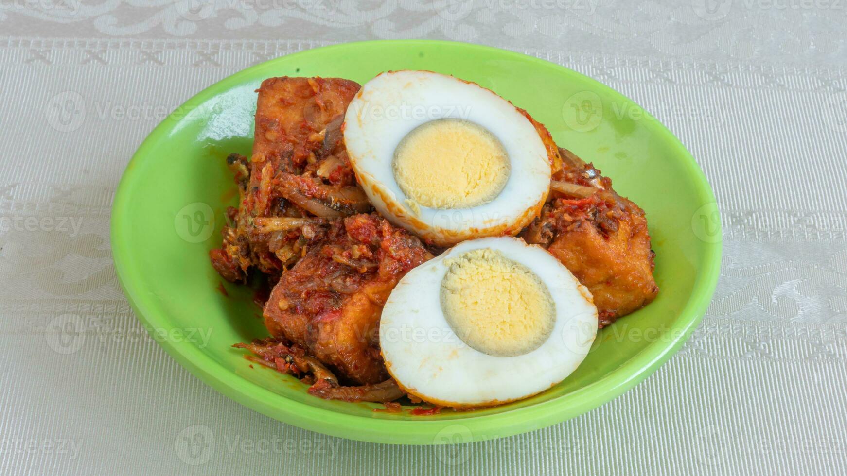 salsa de huevo balado, salsa de chili rellena de huevo, anchoas y tofu. servido en un bol sobre un fondo gris. foco seleccionado. foto