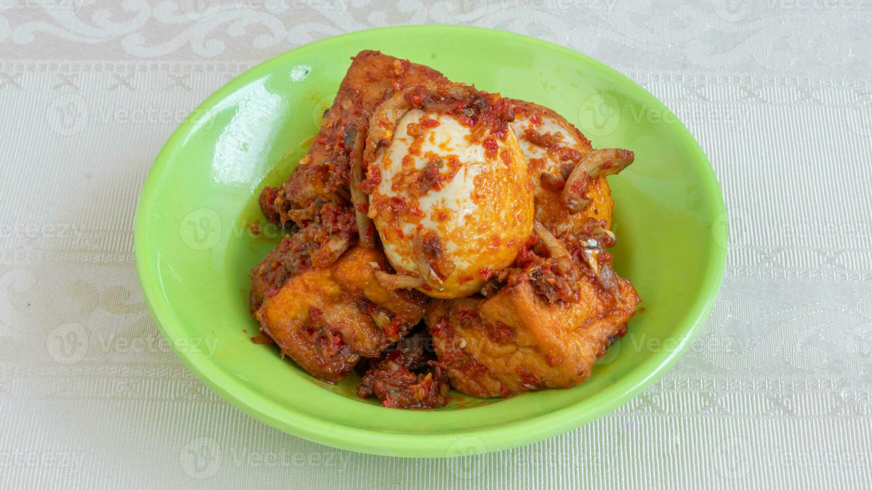 salsa de huevo balado, salsa de chili rellena de huevo, anchoas y tofu. servido en un bol sobre un fondo gris. foco seleccionado. foto