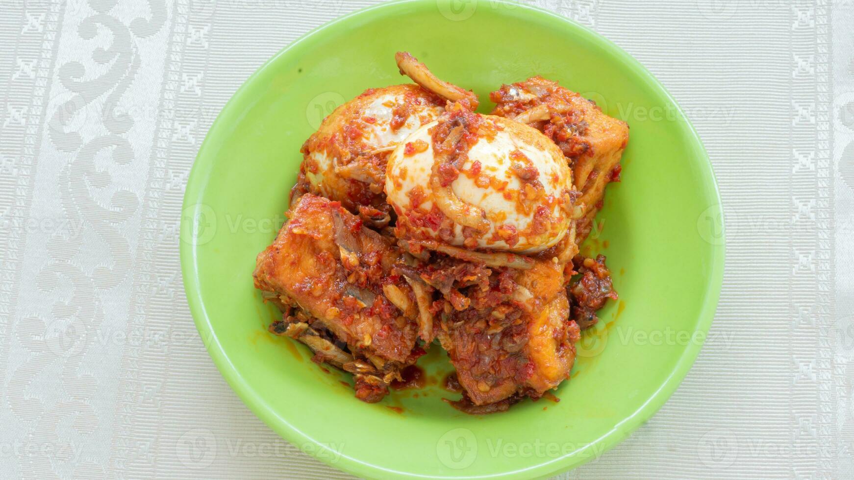 Balado egg sauce, chili sauce filled with eggs, anchovies, and tofu. Served in a bowl on a gray background. Selected focus. photo