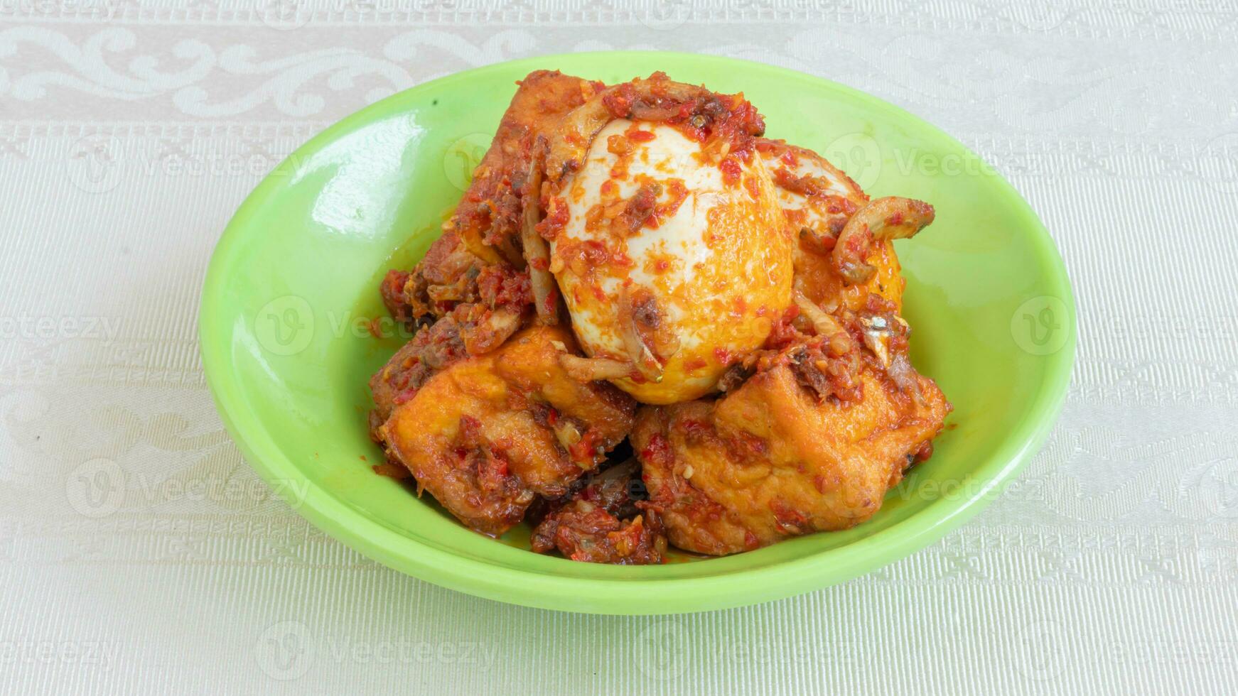 salsa de huevo balado, salsa de chili rellena de huevo, anchoas y tofu. servido en un bol sobre un fondo gris. foco seleccionado. foto