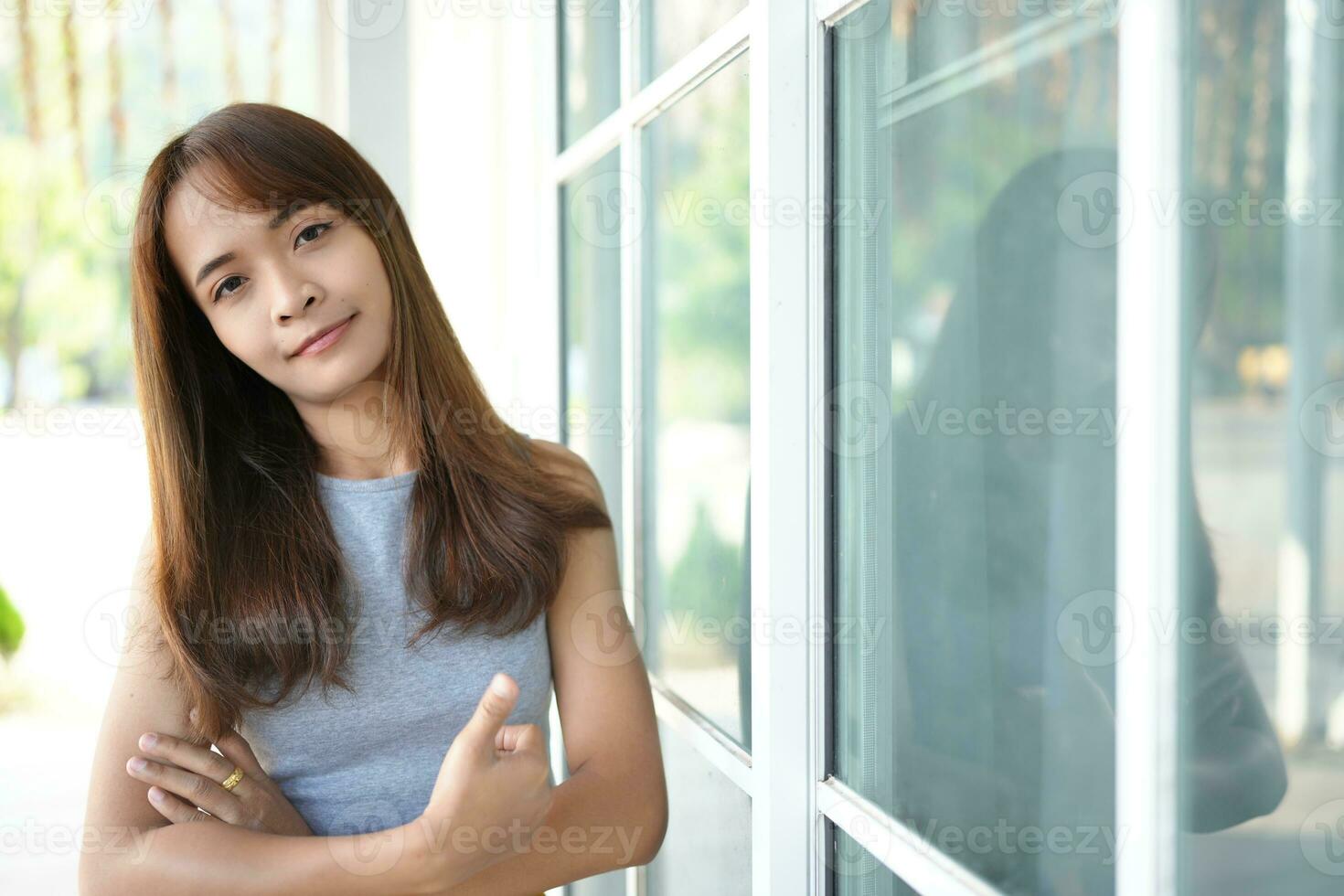 Happy Asian female tourist next to accommodation building during sunset photo