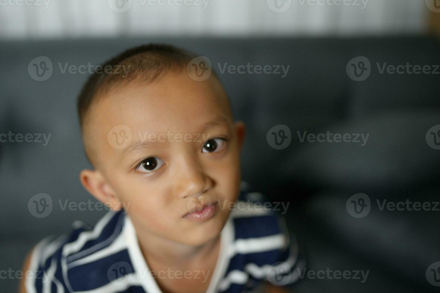 un asiático chico dio él un Mira ese rogó para lástima. foto