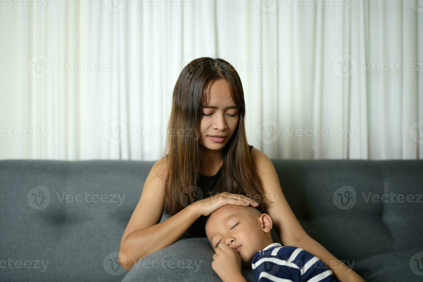 un hijo duerme en su de la madre regazo dentro el casa. foto