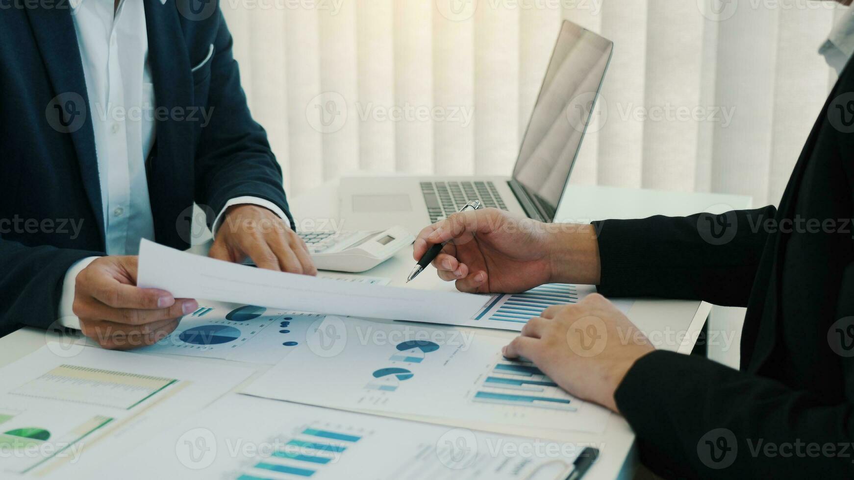 Two business partnership coworkers analysis cost work progress and gesturing with discussing a financial planning graph and company financial during a budget meeting in office room. photo