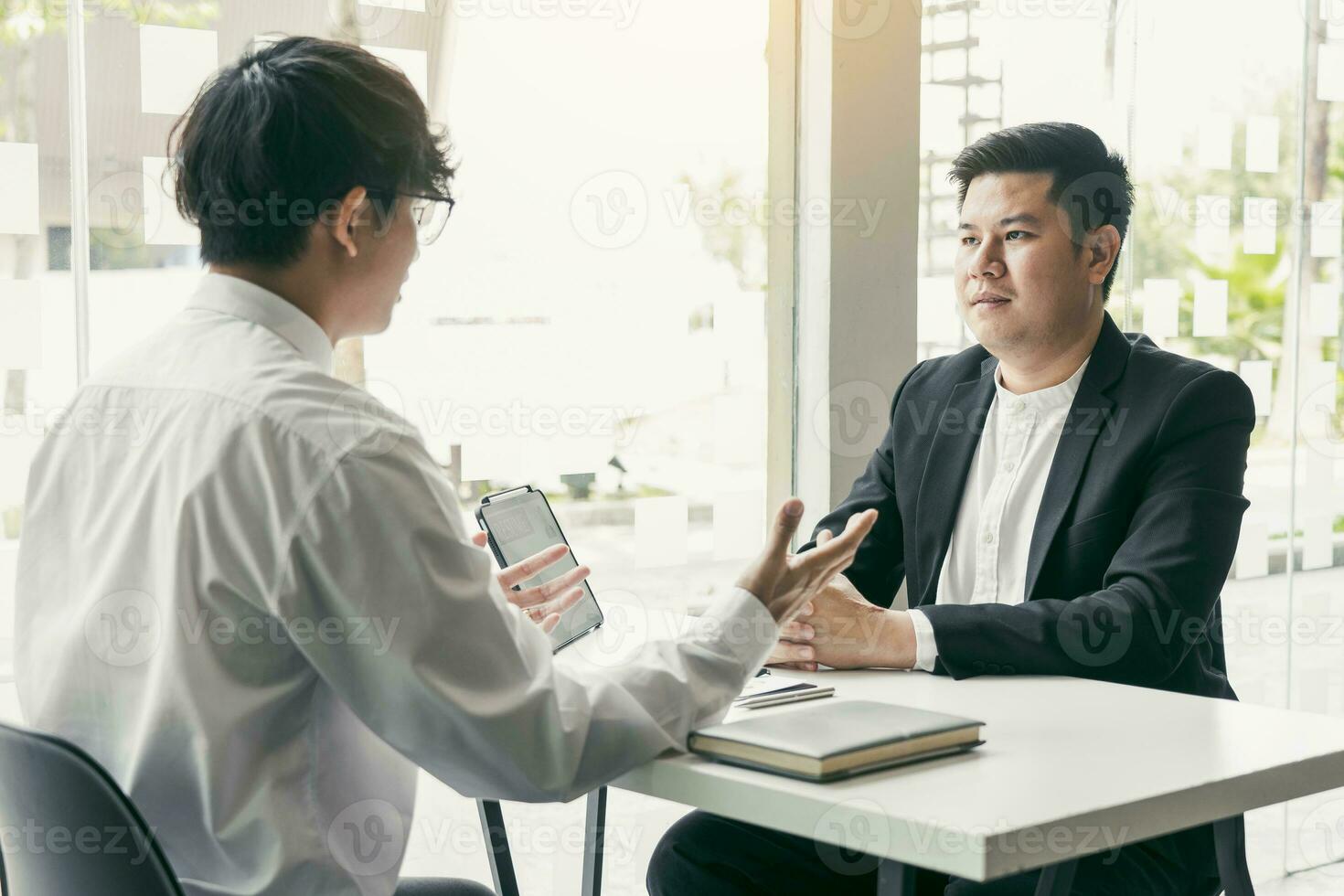 Asian young adult sitting at desk across from manager being interviewed job interview in business room. photo