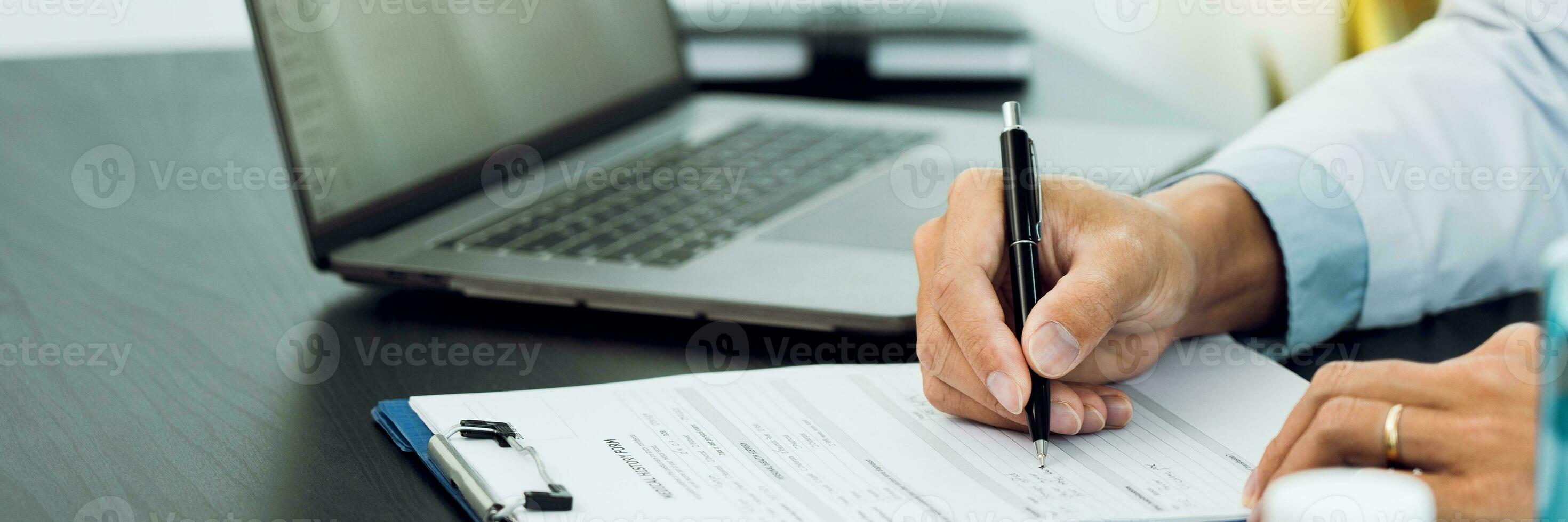 Doctor hand holding pen writing patient history list on clipboard about medication and treatment. photo