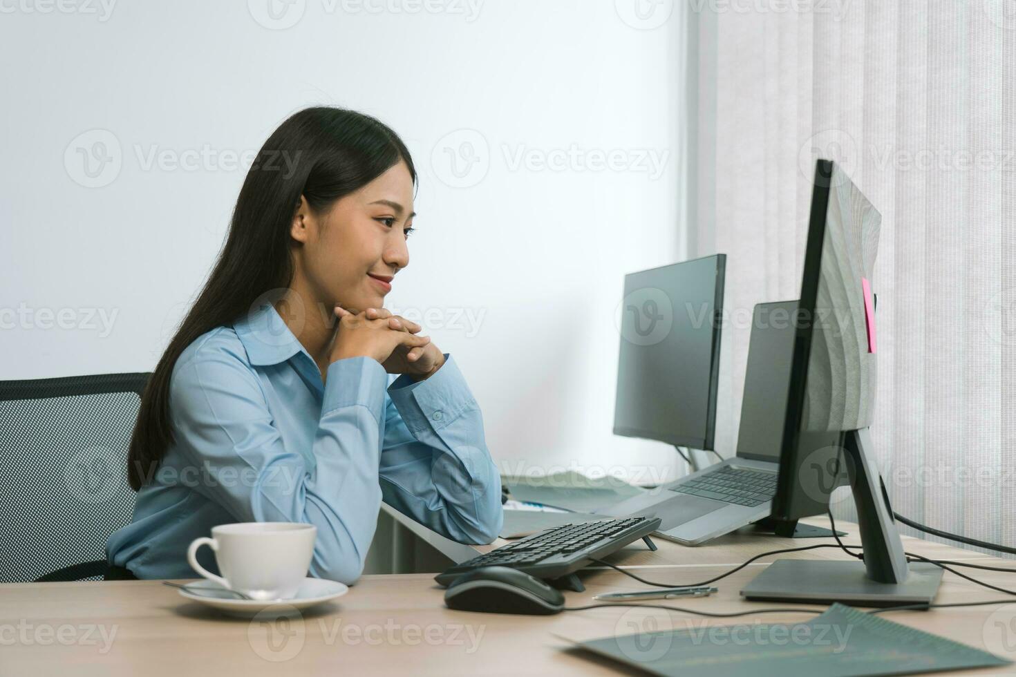 Asian woman software developers sitting in front of computers looking at computer codes on the screen. photo