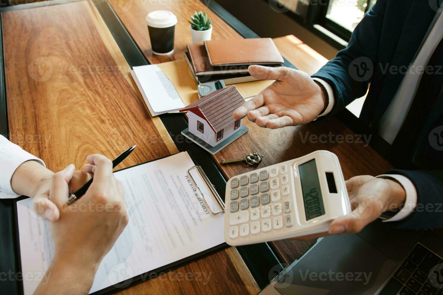 Agents are calculating the loan payment rate or the amount of insurance premiums for customers coming to contact the purchase of a new home at the office. photo