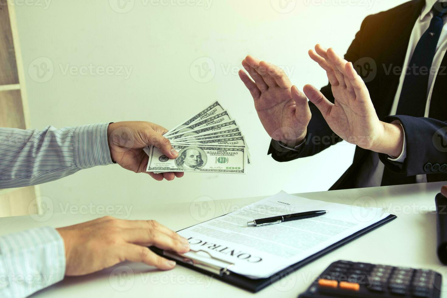 Businessperson refusing bribe given money by partner with anti bribery corruption concept. photo