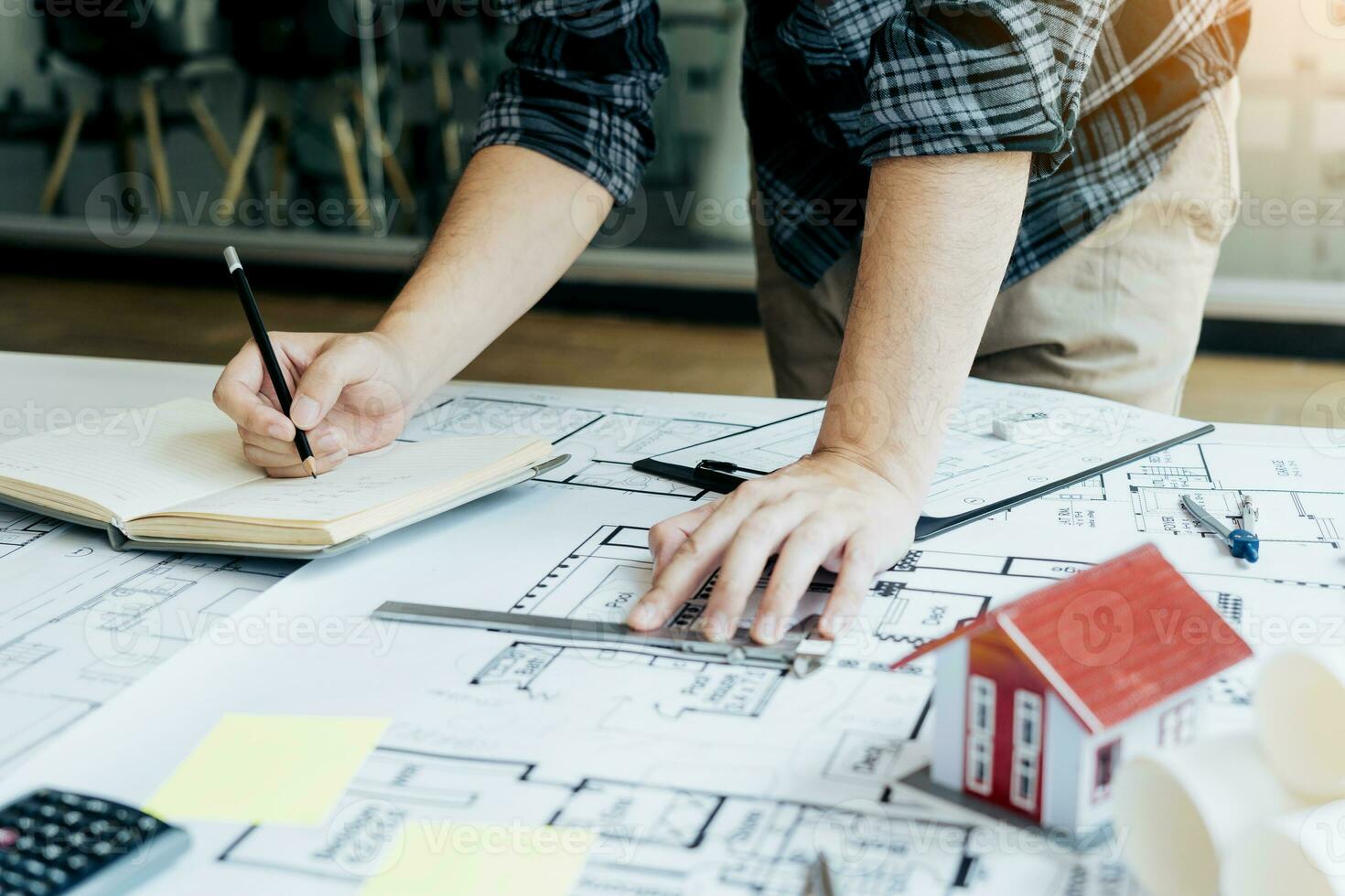 Interior designer or architect reviewing blueprints and holding pencil drawing on desk at home office. photo