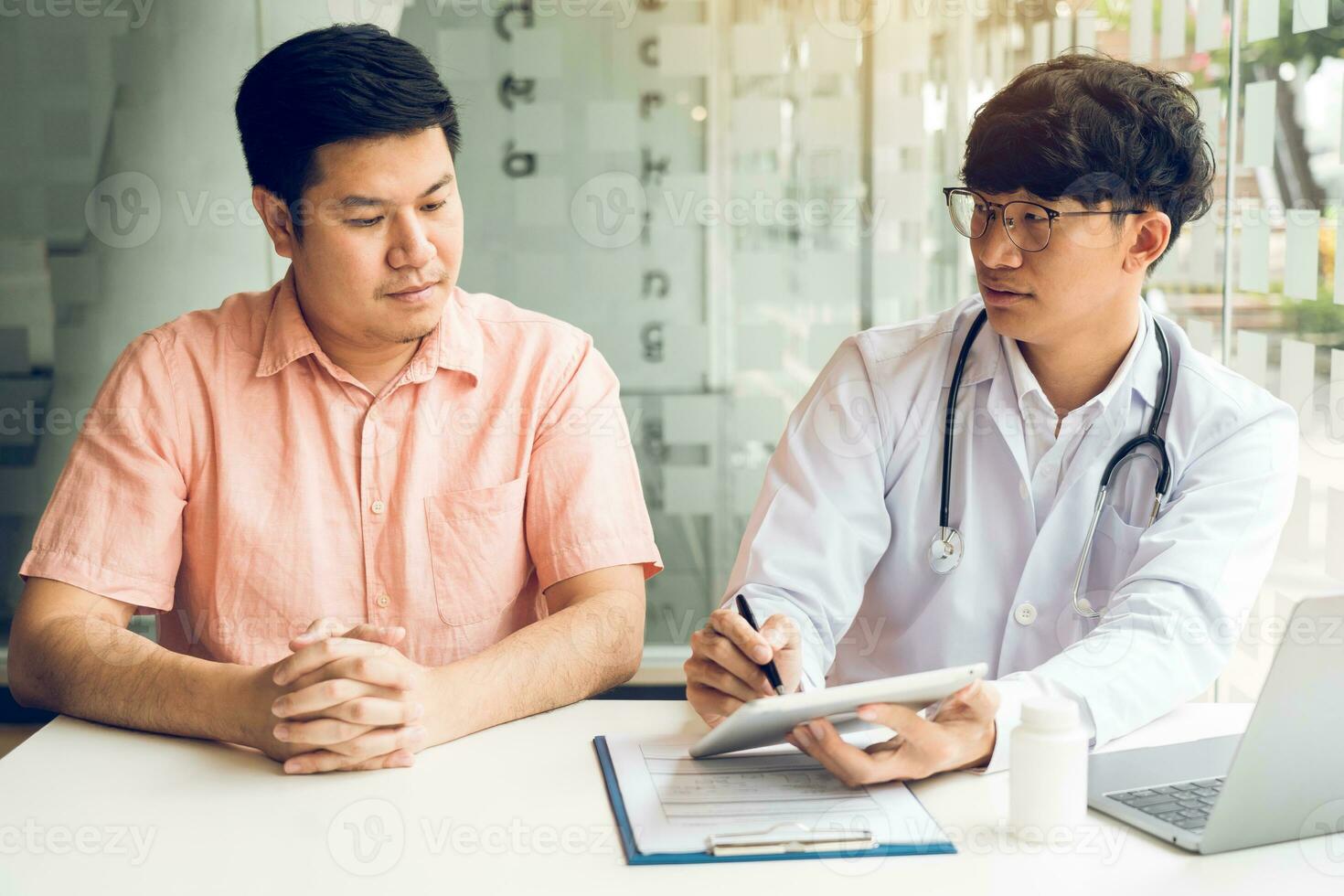 Male patient listening to doctor at desk and consulting with healthcare in hospital. photo