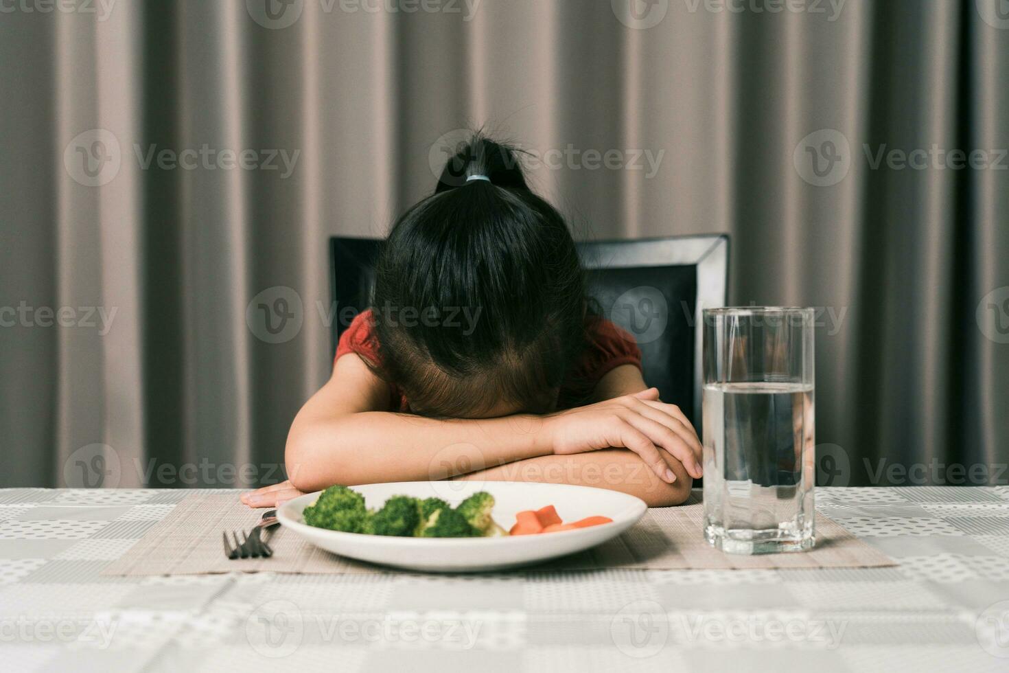 Little cute kid girl refusing to eat healthy vegetables. Children do not like to eat vegetables. photo