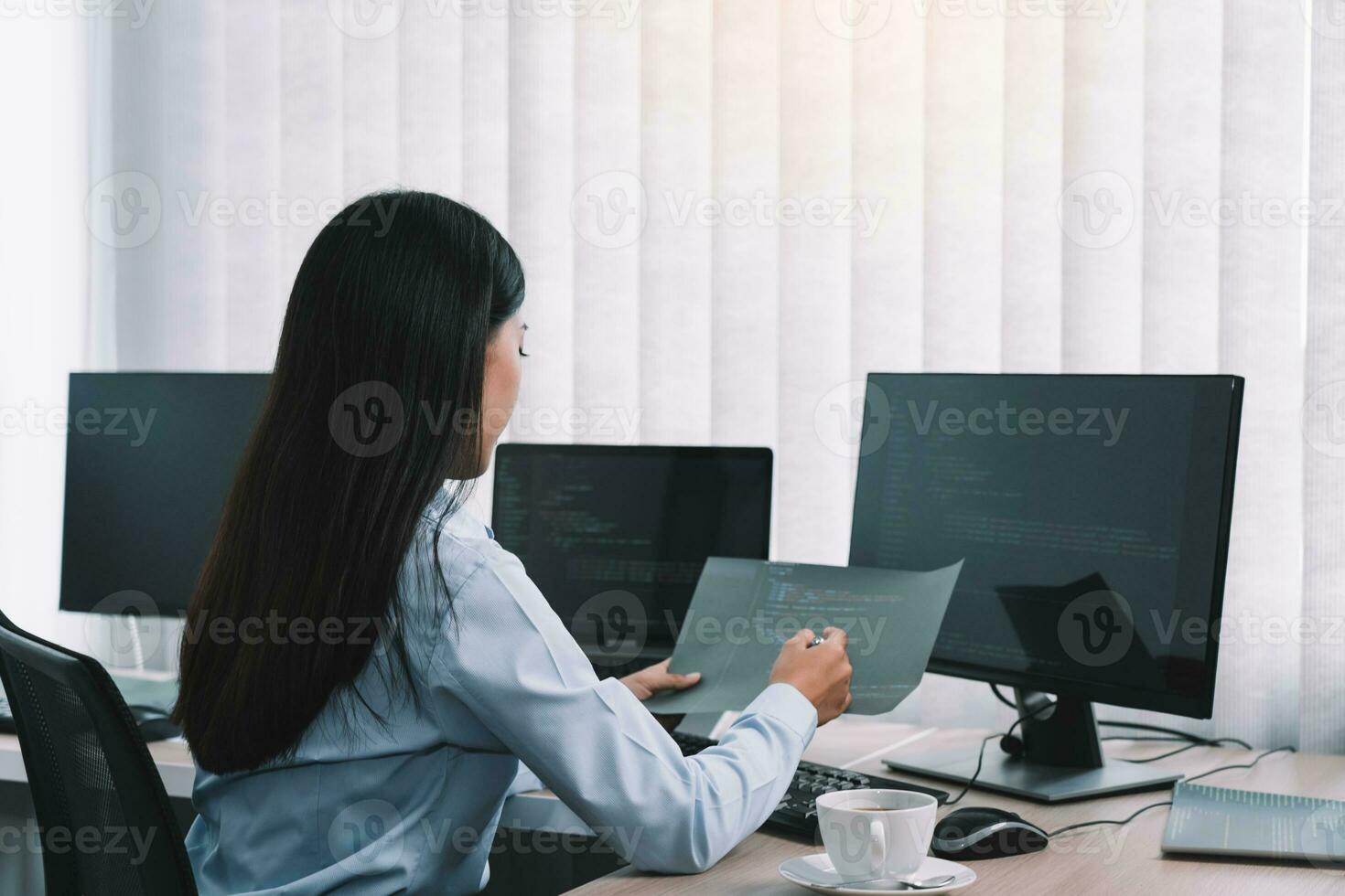 desarrolladores de software de mujeres asiáticas sentadas frente a computadoras mirando códigos de computadora en la pantalla. foto