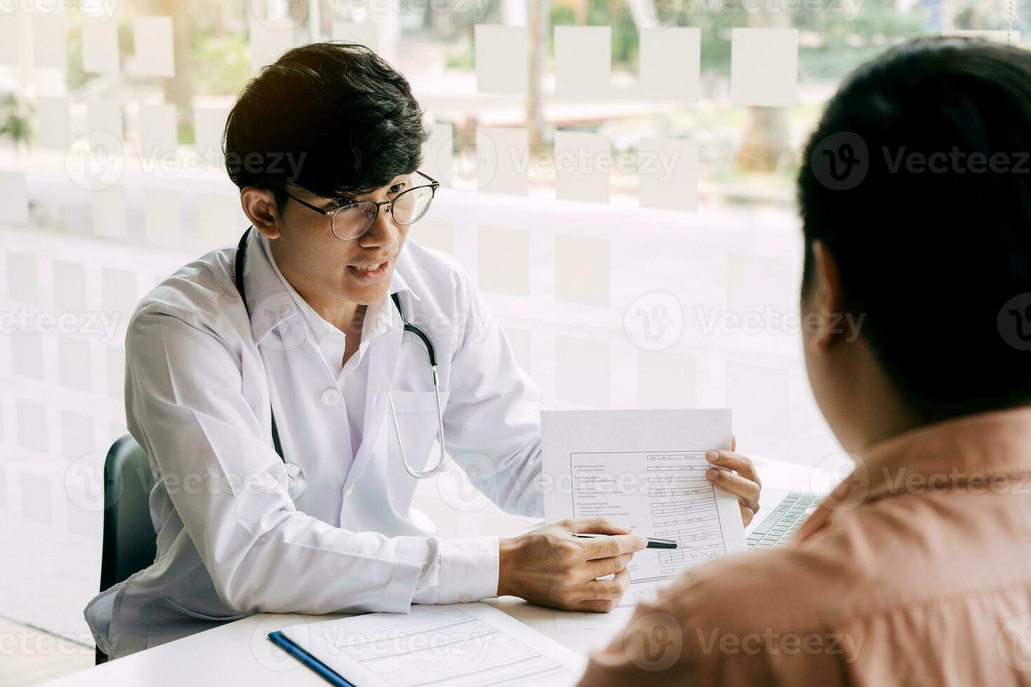 The doctor is explaining the treatment of the patient's illness at the office. photo