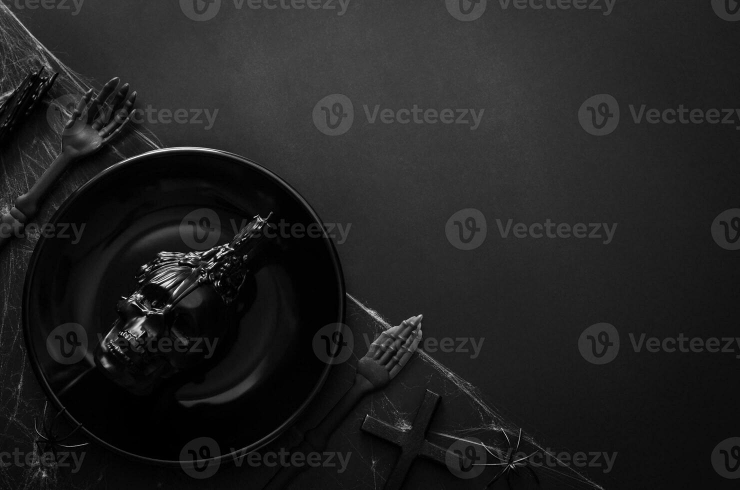 Halloween dining party concept with black plate that have skull candle put on cobweb and black background. photo