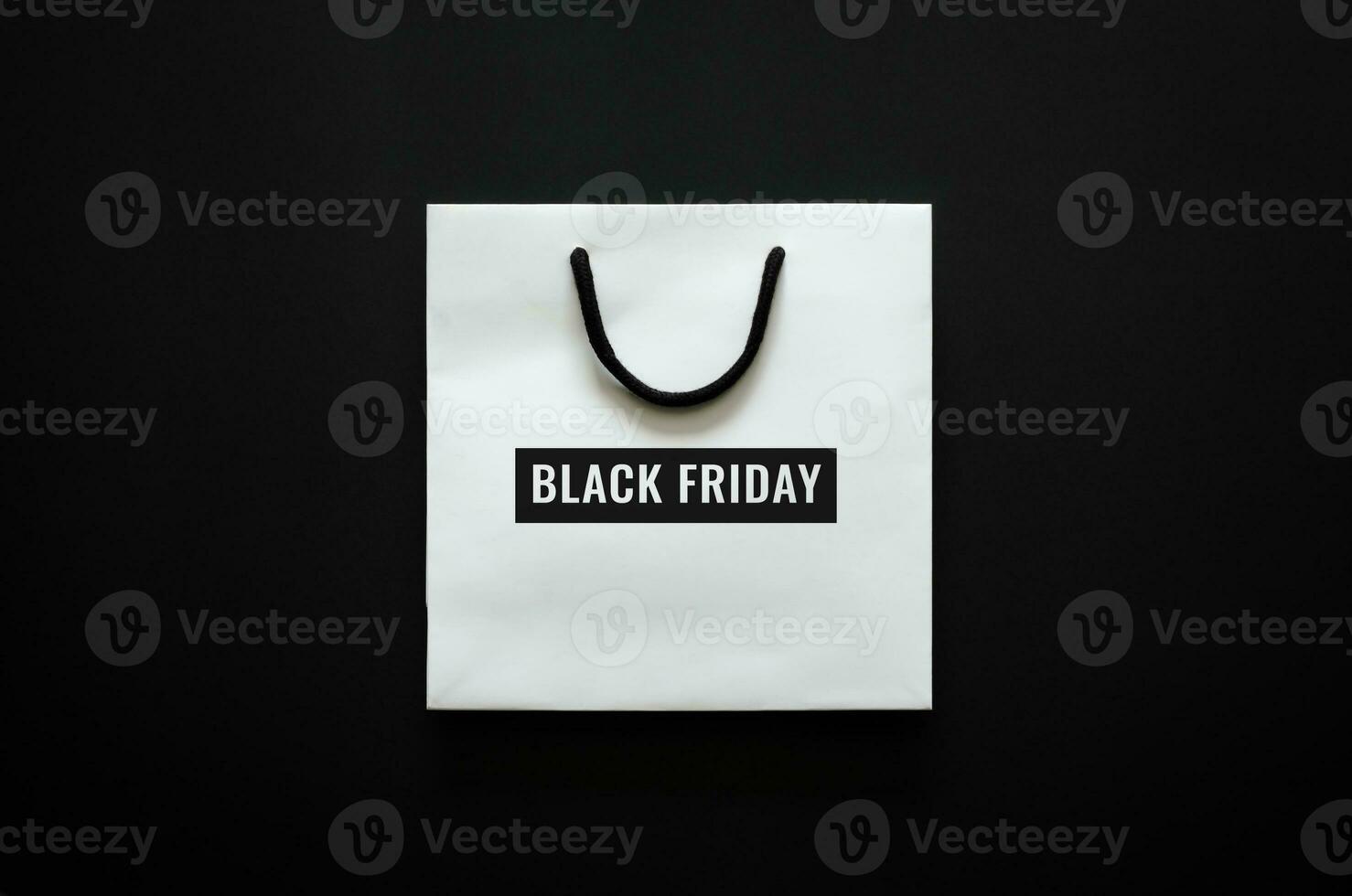 White shopping bag with Black Friday word on black background for Black Friday shopping concept. photo