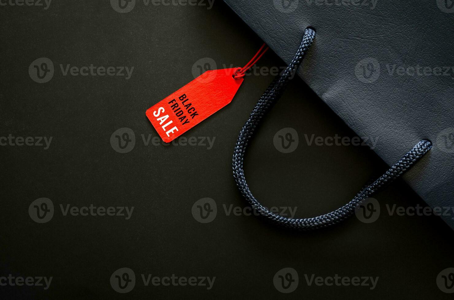 Dark blue shopping bag with word on red price tag on black background for Black Friday shopping sale concept. photo