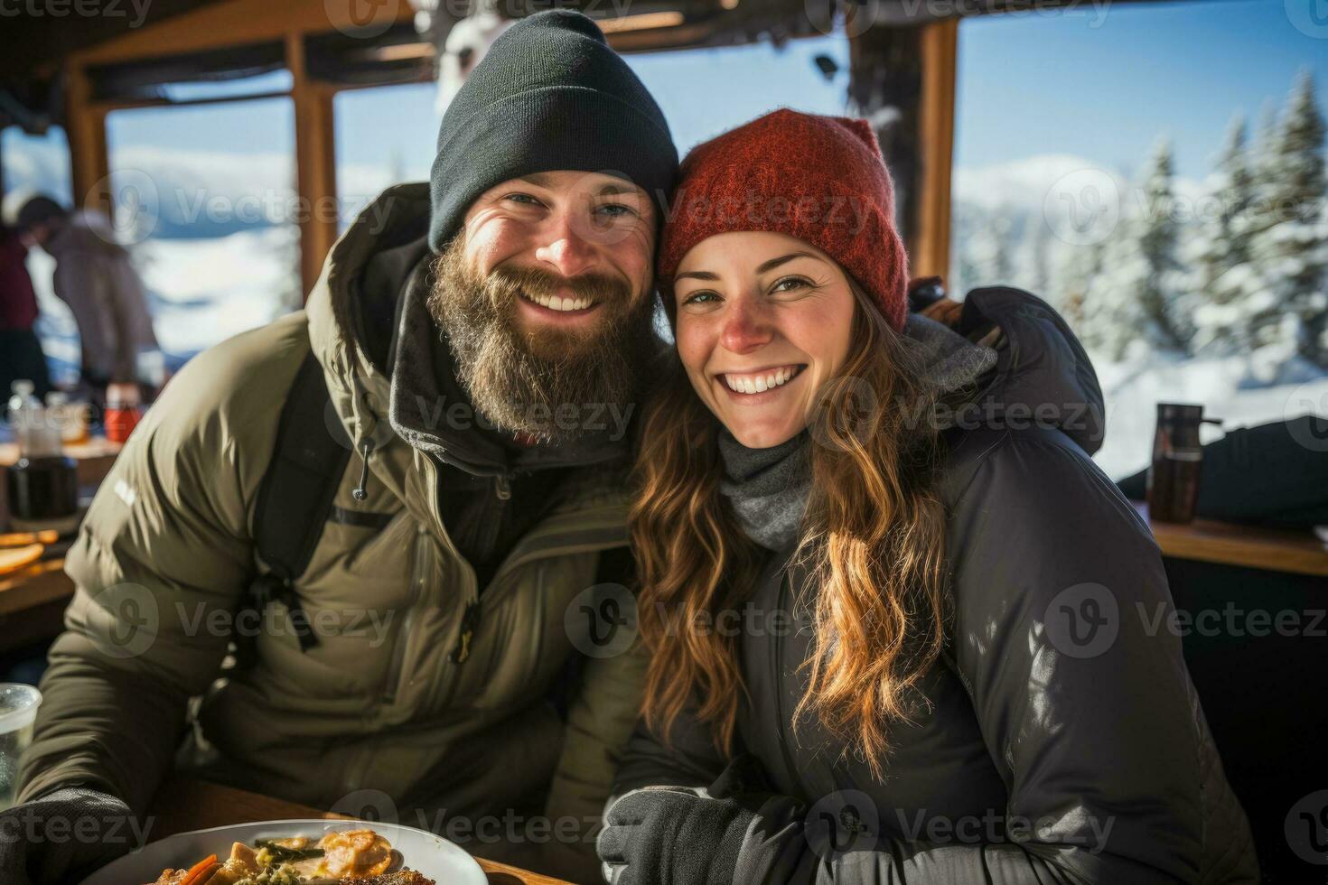 Couples snowshoeing in winter gear pausing for hot drinks and toasted sandwiches photo