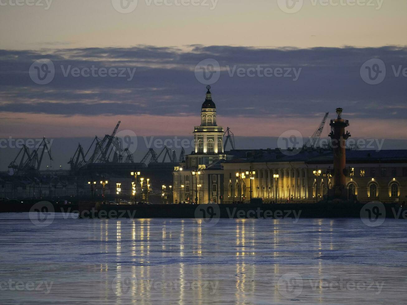 Duwn city center. Spring evening in St. Petersburg. Ice on the Neva River. View of the Rastral columns and Cabinet of curiosities at sunset, city life, postcard view of the evening city. photo