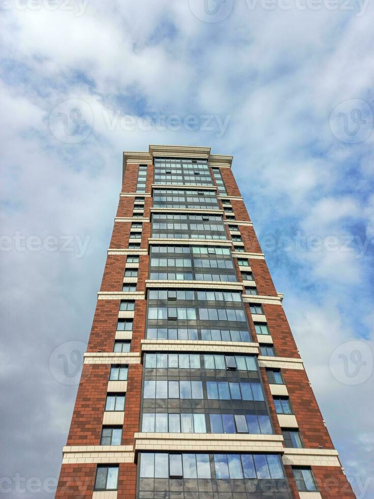 Modern beautiful new buildings. Colored wall on the background of blue sky. Modern construction, new neighborhood. Copy space, vertical view. photo