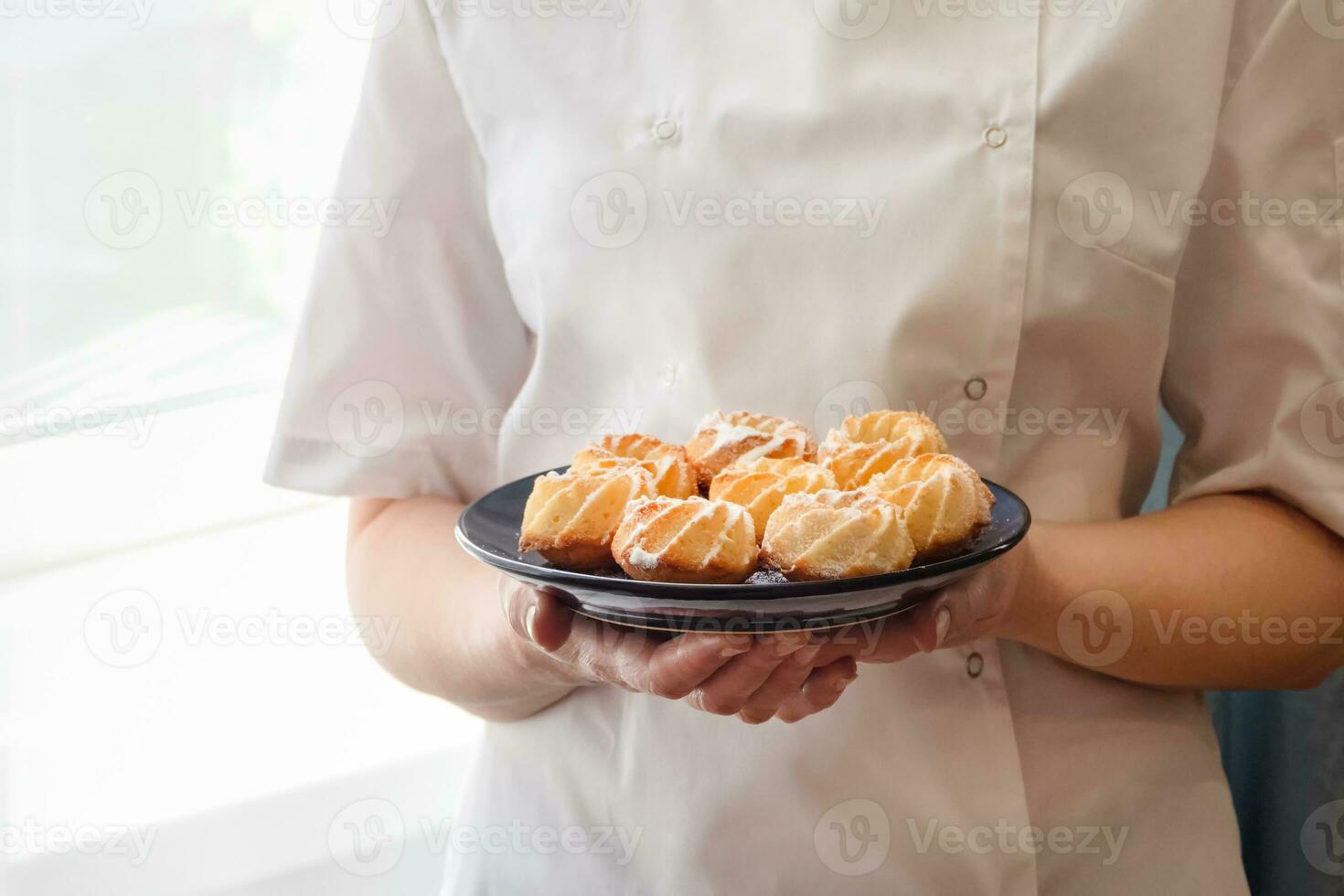 Cropped image of Woman chef holding fresh and tasty freshly baked coconut cookies. photo